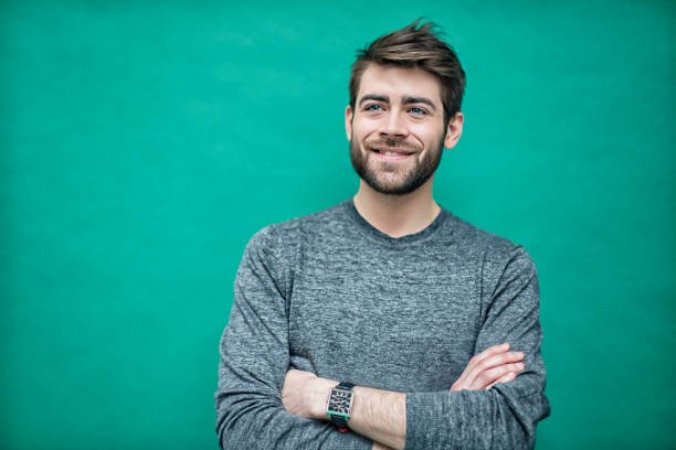 Portrait of a young french man on a green background.